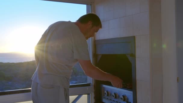 Een man op zelf-isolatie tijdens quarantaine patat steaks thuis. — Stockvideo