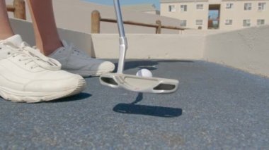 Golf sopasını yakın çekimde bir golf topuna vur - mini golf.