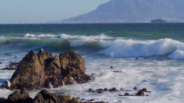 Atlantik Okyanusu 'ndaki dalgaların manzarası Cape Town, Güney Afrika Tablosu Dağı' nın arka planında bir gemi var..