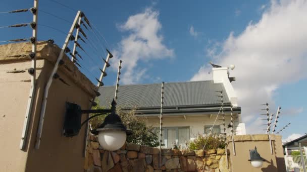 Panning colpo di recinzione elettrica su un muro alto. Protezione della proprietà, sicurezza della residenza. — Video Stock