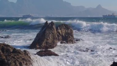 Atlantik Okyanusu 'ndaki dalgaların manzarası Cape Town, Güney Afrika Tablosu Dağı' nın arka planında bir gemi var..