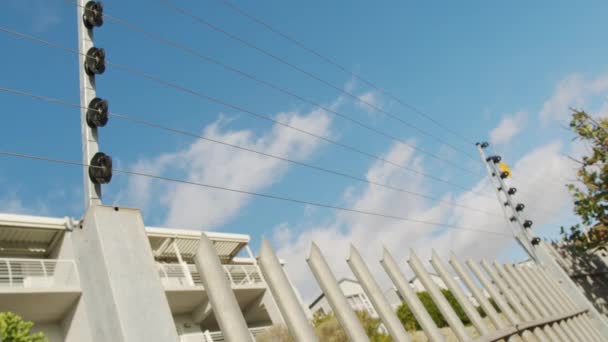 Clôture en fil barbelé. Plan panoramique de clôture électrique sur un haut mur. — Video