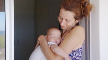 Annesinin sarılıp öptüğü, uyuyan kızının onu kollarıma aldığı yakın plan..