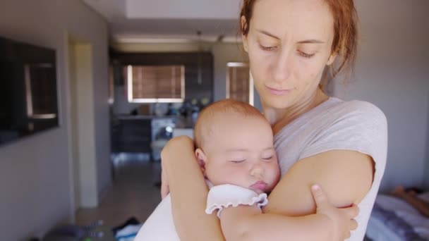 Close up de mãe abraçando e beijando dormindo bebê filha segurando-a em meus braços. — Vídeo de Stock