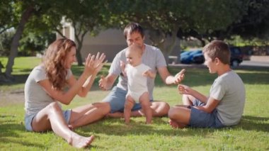 Bebek çimenlerde ilk adımı atıyor. Aile kızıyla birlikte doğa çocuğunun hayalindeki gibi yürür. Bebek annesiyle ilk adımı atıyor. Mutlu bir aile..