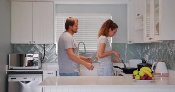 Mutlu, olgun bir çift mutfakta flört ediyor, romantik bir ilişki yaşıyorlar. Karı ve koca arasında samimi bir bağ var. Birlikte mutlu bir hayat sürüyoruz.. — Stok video