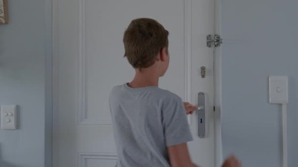 Αγόρι ανοίγει τις πόρτες του σπιτιού του και συναντά τον άνθρωπο παράδοσης που δίνει το χαρτόνι του ταχυδρομικό πακέτο. — Αρχείο Βίντεο