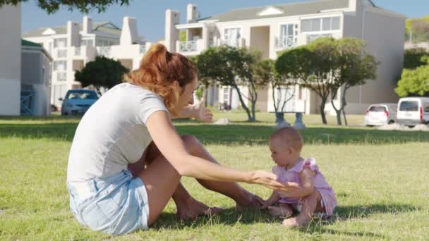 Parkta yürüyüş yapan mutlu anne ve bebek. Güzel kız, annesinin desteğiyle ayağa kalk. Çocuklarla birlikte yürümeyi öğreniyoruz. Hayattaki ilk adım. — Stok video