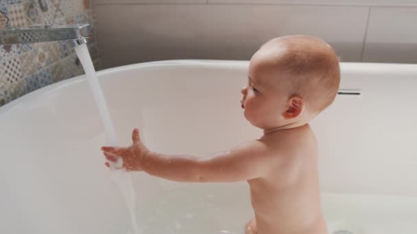 Bayi di Awe of Water Stream. Sebuah aliran air yang keluar dari keran dan bayi melihat air dengan takjub. — Stok Video