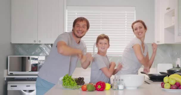 Zabawna szczęśliwa rodzina i słodkie dzieci zabawy taniec w kuchni razem, active mama tata korzystających funky taniec z synem. — Wideo stockowe