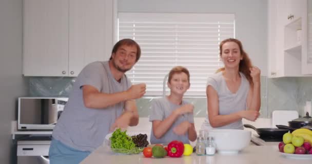 Funny happy family and cute children having fun dancing in kitchen together, active mom dad enjoying funky dance with son. — Stock Video