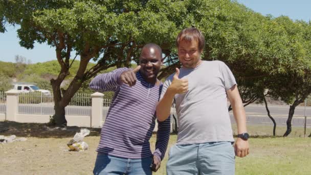 Hombre negro y hombre blanco abrazándose y sonriendo. Igualdad, concepto de complicidad de amistad. Retrato cercano de jóvenes estudiantes. No hay racismo. — Vídeos de Stock