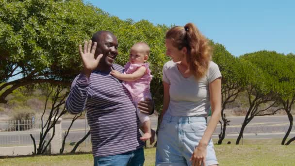 Νεαρή διαφυλετική οικογένεια με μικρό παιδί να χαμογελά στην κάμερα. — Αρχείο Βίντεο