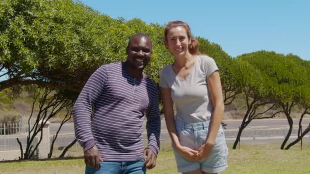 Outdoor portrait of a happy man and woman. A black guy and a white girl are smiling. Black and white couple in love. — Stock Video
