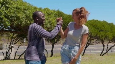 Mutlu bir erkek ve kadının açık hava portresi. Siyah bir adam ve beyaz bir kız gülümsüyor. Siyah beyaz çift aşık..