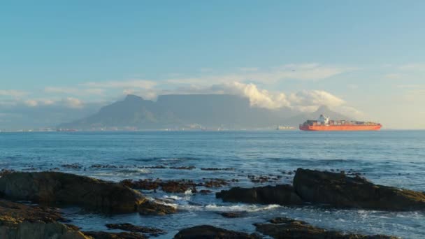 Capetown-ban. Gyönyörű tiszta nap keres asztal hegyi és anyaváros óceán hullámok összeomlik felett sziklás partvonal. — Stock videók