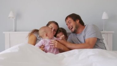 Küçük çocukları olan mutlu bir aile. Gıdıklanan bir kız çocuğu. Birlikte eğleniyorlar..