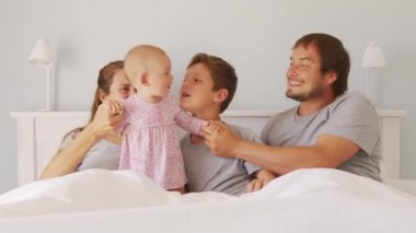 Küçük çocukları olan mutlu bir aile. Gıdıklanan bir kız çocuğu. Birlikte eğleniyorlar..