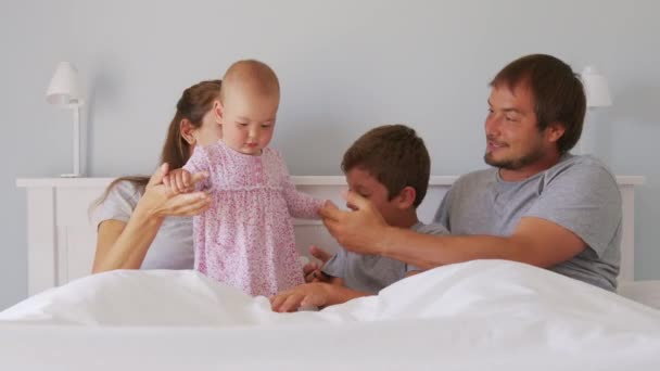 Glückliche Familie mit niedlichen kleinen Kindern Sohn Tochter kitzeln Spaß haben entspannen auf schlechten zusammen, junge unbeschwerte Eltern und Kinder lachen. — Stockvideo