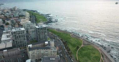 Arka planda Masa Dağı 'nın olduğu muhteşem bir günbatımında Cape Town' a doğru ilerleyen geniş bir hava görüntüsü..