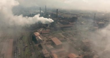 Duman emisyonlu yüksek boruların destansı havası. Bitki boruları atmosferi kirletir. Endüstriyel fabrika kirliliği, baca bacası egzoz gazı. Endüstri bölgesi, yoğun duman bulutları. İklim değişikliği, ekoloji.