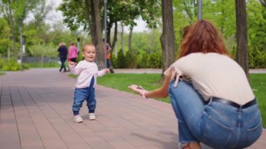 Küçük kız ilk adımı atıyor. Aile yaz tatili kavramı, açık hava oyunları, ilk adımlar, çocuk gelişimi.