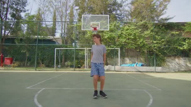 मुलगा स्ट्रीट बास्केटबॉल प्रशिक्षण. एकटे बास्केटबॉल मैदानी सराव केंद्रित स्ट्रीटबॉल खेळाडू . — स्टॉक व्हिडिओ