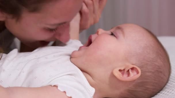 Primer plano madre besos feliz bebé riendo disfrutando amoroso mamá nutrir niño en casa. — Vídeo de stock