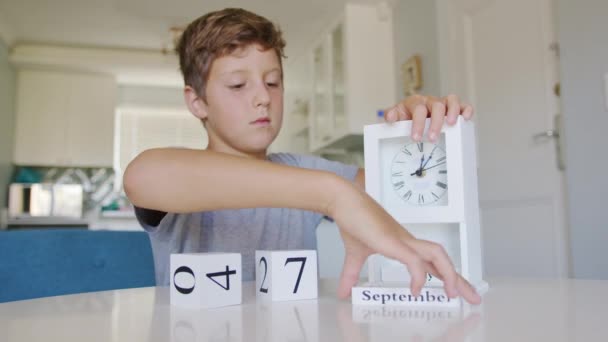 Chłopiec odwraca kostki w kalendarzu na wrzesień 1. — Wideo stockowe