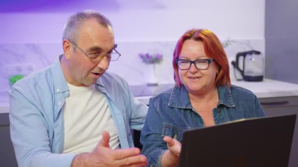 Счастливая пожилая пара со средним возрастом, разговаривая на ноутбуке, делая онлайн-покупки, пожилые взрослые семьи читать обсуждая интернет-компьютерные новости. — стоковое видео
