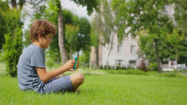 Niños juega pop it juguete simple hoyuelo de pie en la calle. — Vídeos de Stock