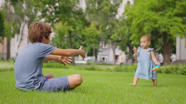 Kislány a bátyjával, játszadozik az utcán.. — Stock videók