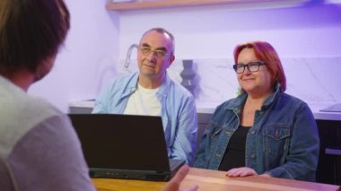 Mutlu orta yaşlı aile çifti erkek emlakçı, mali danışman ya da avukatla tanışıyor sözleşme detaylarını tartışıyor, ofiste anlaşma yapıyor..