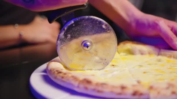 Couper la pizza avec un couteau de coupe rond. Gros plan de délicieuses pizzas coupées en morceaux. — Video