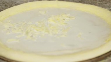 Pizza hamuruna taze rendelenmiş peynir serpiştiriyorum. Şef pizza pişiriyor. Geleneksel İtalyan pizzası hazırlama süreci.
