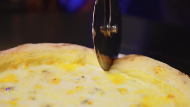 Cortar la pizza con un cuchillo de corte redondo. Primer plano de deliciosa pizza cortada en pedazos. — Vídeos de Stock
