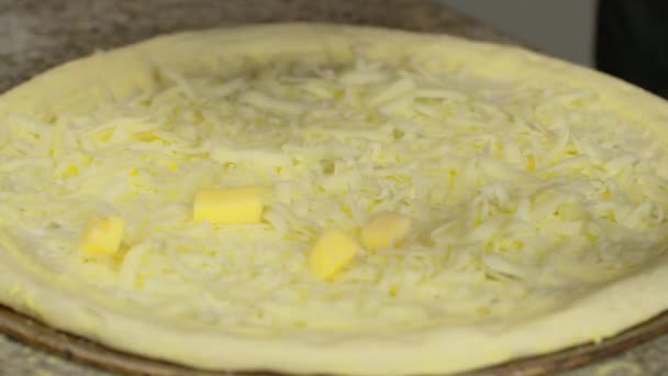 Sprinkling fresh grated cheese on pizza dough, close up. Chef is cooking pizza. Process of preparing traditional italian pizza. — 图库视频影像