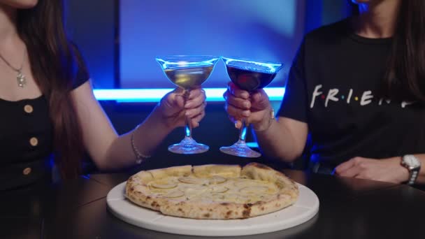 Närbild skott av en ung bekymmerslös romantiska par flickor i kärlek dricker och hejar med coola alkohol cocktails samtidigt som du njuter av en glad timme tillsammans i stadens centrum bar på en helg. — Stockvideo