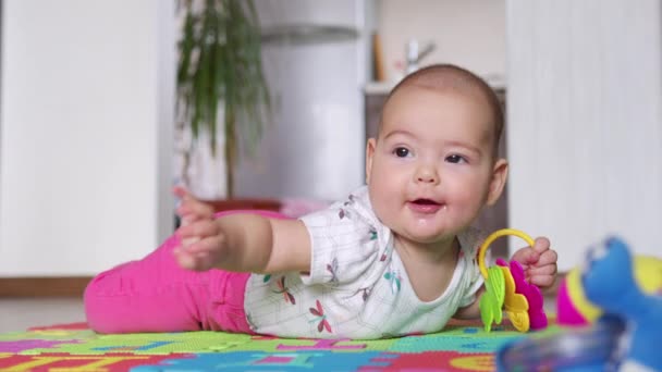 Porträt eines netten Neugeborenen, das auf dem Bauch liegt und interessiert in die Kamera schaut. — Stockvideo