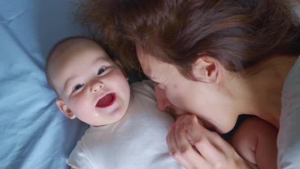 Foto dekat dari ibu muda sedang bermain dengan bayinya yang baru lahir di kamar bayi di pagi hari. Konsep anak-anak, bayi, orang tua, masa kecil, kehidupan, ibu. — Stok Video