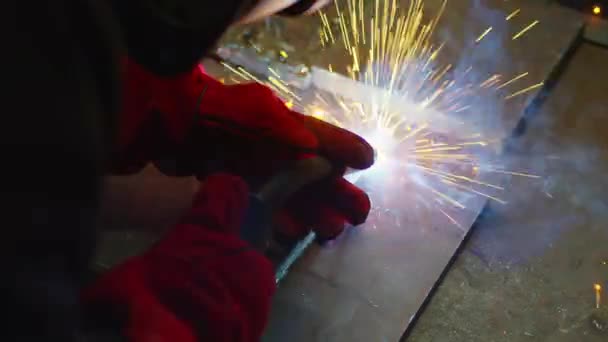 Trabajador industrial en máscara protectora que utiliza la soldadora moderna para soldar la construcción metálica en la fabricación de producción en la fábrica de metalurgia. — Vídeos de Stock