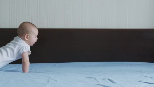 Gelukkig baby meisje kruipen op bed peuter verkennen thuis nieuwsgierig zuigeling hebben plezier genieten van de kindertijd. — Stockvideo