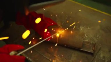 Fabrikada çelik kaynak makinesiyle çalışan metal kaynakçı güvenlik ekipmanı takıyor. El becerisi iş gücü kavramına göre metal imalatı ve inşaat bakım hizmeti.