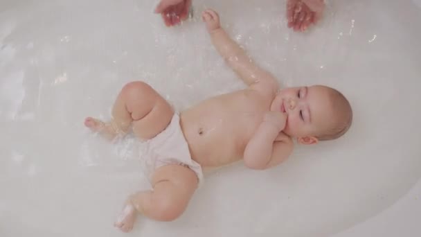 Baby Close Up Playing in Bath. Top view of funny newborn baby swimming during bathing. — Stock video