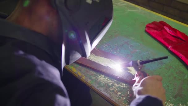 在保护面罩中的特写铁匠焊机采用金属钢和铁制，使用焊机，明亮的火花和极慢的闪光. — 图库视频影像