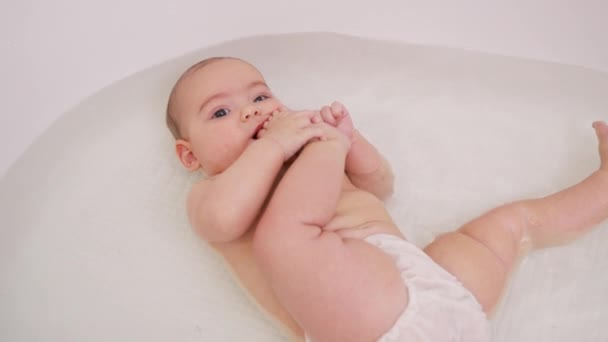 Купание младенца в ванне. — стоковое видео