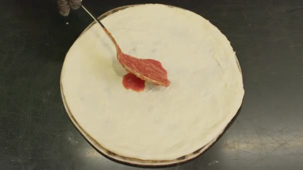 Close Up of Chef está extendiendo salsa en masa de pizza en la tradicional pizza italiana. — Vídeos de Stock