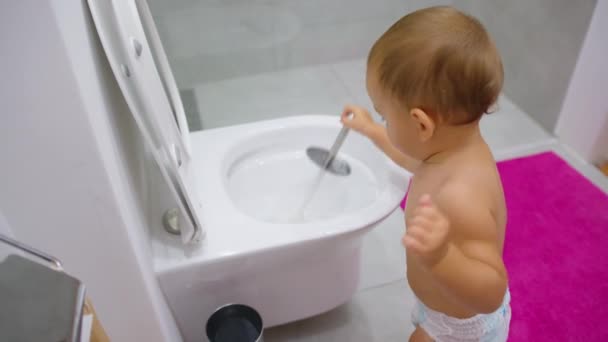 Ребенок моет туалет. Ребенок убирается дома. Домашние обязанности. — стоковое видео