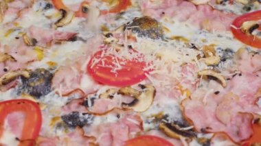 Pişmiş pizzaya taze kişniş serpiştiren bir şefin yakın plan görüntüsü. Yeni pişmiş pizzaya garnitür serpiyorum. İzolasyon döneminde evde yemek pişirmek, 2021 salgını. Evde kal konsepti.