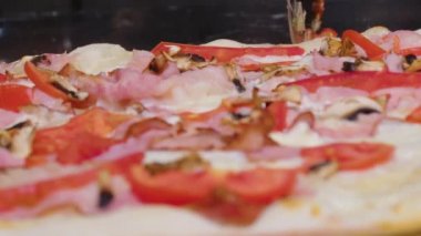 Yuvarlak bir bıçakla pizza kesmek. Lezzetli pizzanın parçalara ayrıldığı yakın plan..